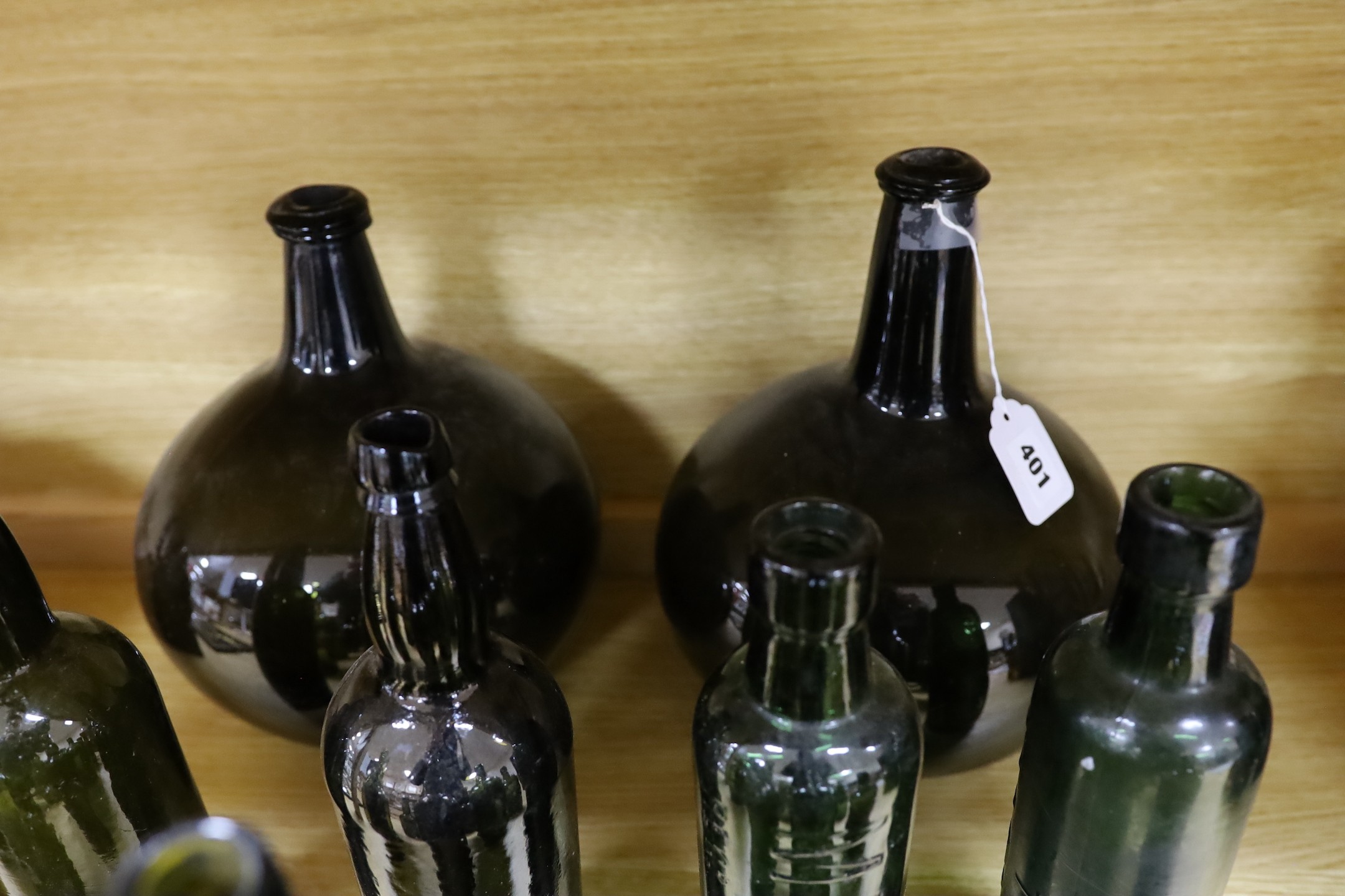 A pair of 18th century green glass onion bottles and a large quantity of other green glass bottles, tallest 38cm
